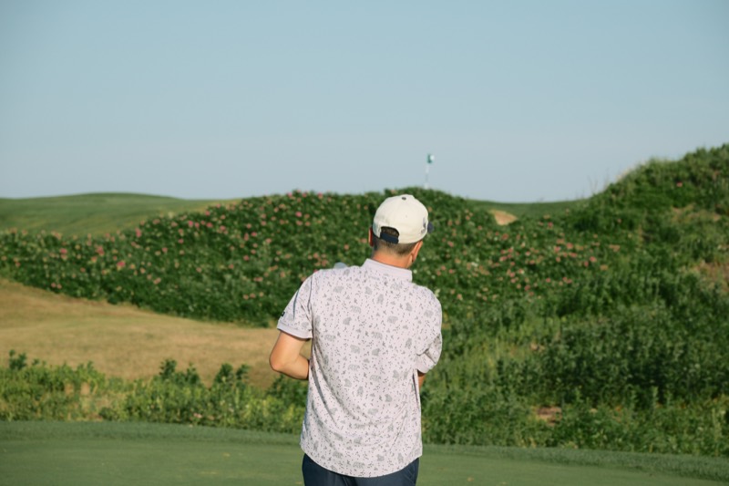 A player watching a shot toward a hilltop flag