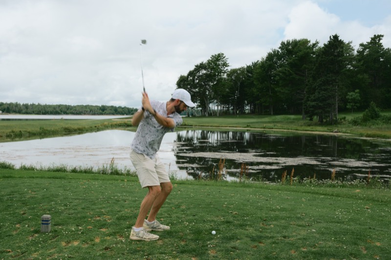 A Bears player watching a tee shot fly over a pond