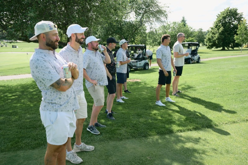 A line of Bears players watching a shot from the side of a fairway