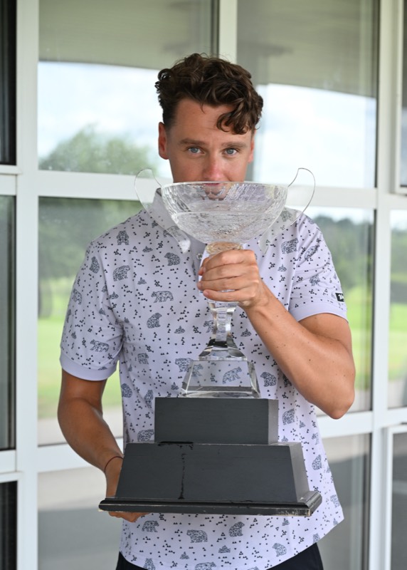 A Bears player carrying the cup in front of the clubhouse