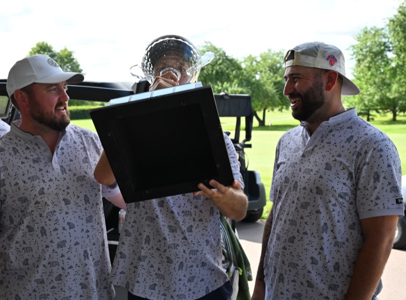 Three Bears players laughing as one lifts the cup